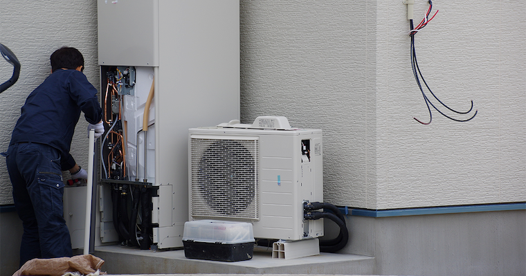 写真 給湯器を業者の人が設置している